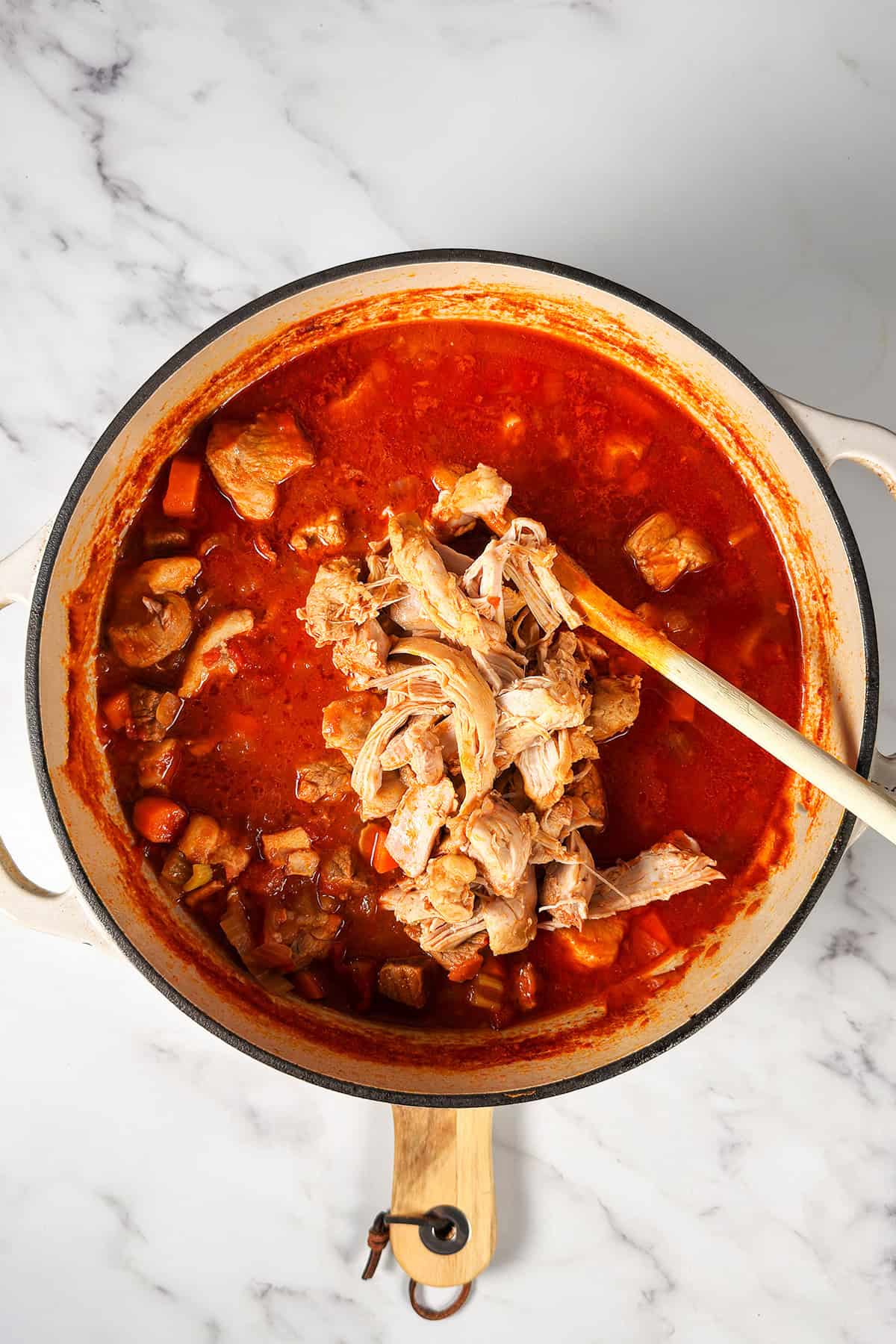 Shredding chicken for a pot of hearty Burgoo, a tomato-based stew.