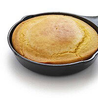 Side view of skillet cornbread in a cast iron skillet