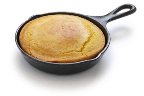 Side view of skillet cornbread in a cast iron skillet