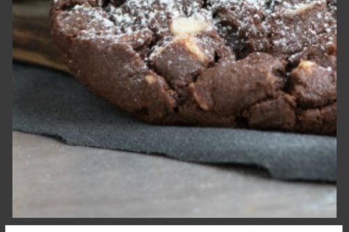 A close-up of a dark chocolate espresso cookie with powdered sugar on top, resting on a dark surface. Text below reads: "Dark Chocolate Espresso Cookies, 31Daily.com".