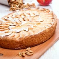 German Apple Kuchen cake on a wooden board on a white background.