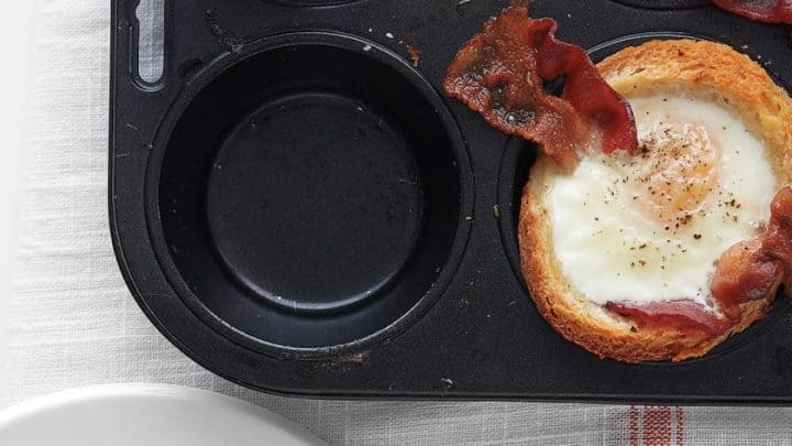 Top view of Sunshine Egg and Bacon Cups in a black muffin tin.