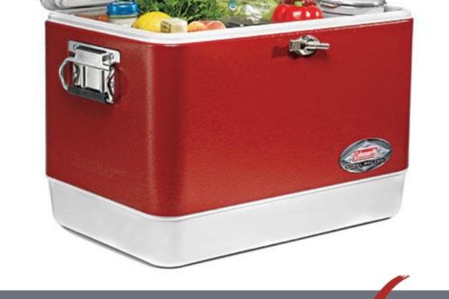 A red and white cooler with its lid open, revealing various food items inside, including vegetables and bottled drinks. The text at the bottom reads "How to Pack a Cooler" with a red checkmark next to it. The URL "31Daily.com" is visible in the bottom left corner.