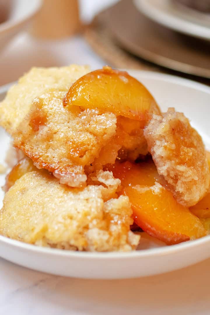 Old-fashioned peach cobbler with fresh peaches and a golden buttery topping.