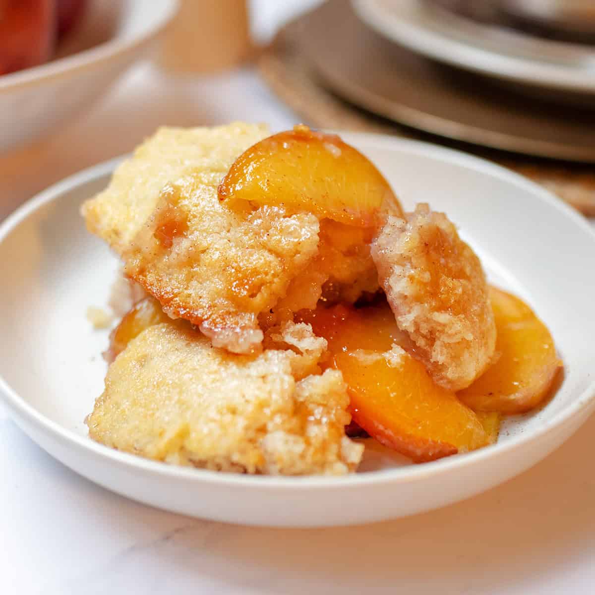 Old-fashioned peach cobbler with fresh peaches and a golden buttery topping.