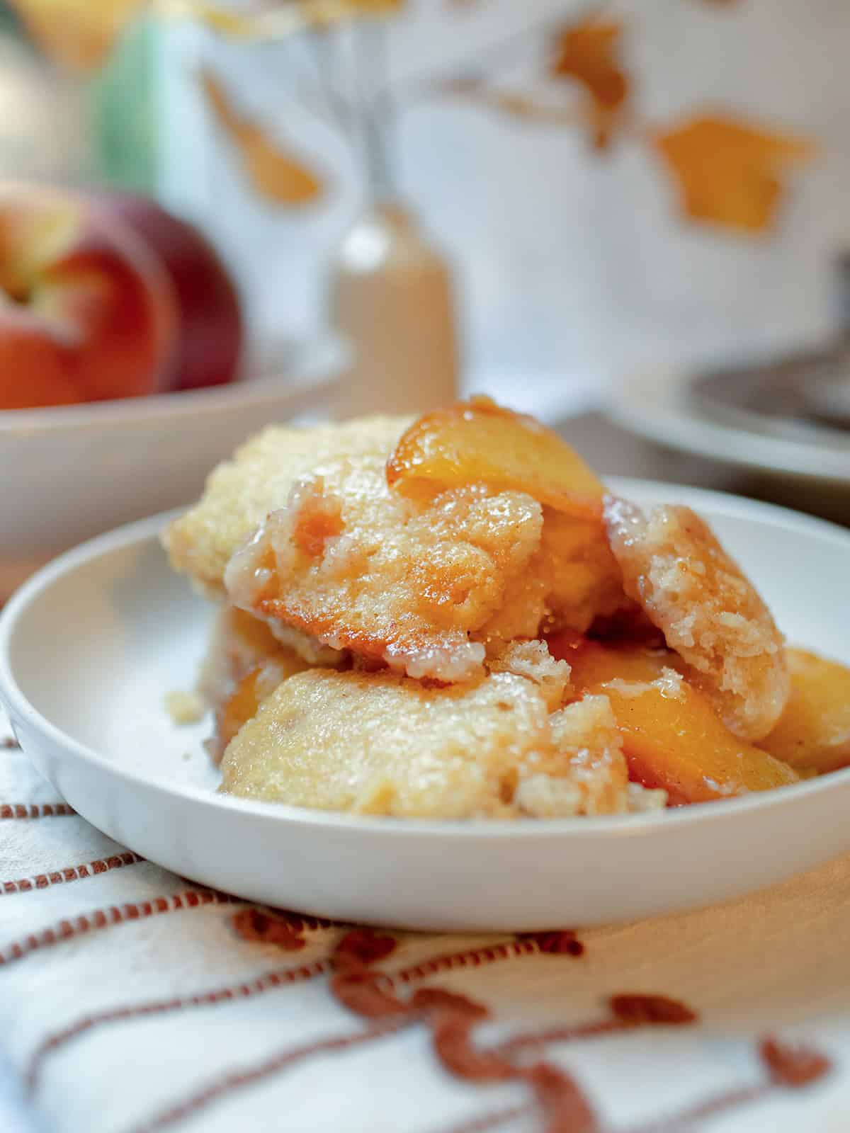 Serving of homemade peach cobbler with juicy peaches and a golden baked topping.