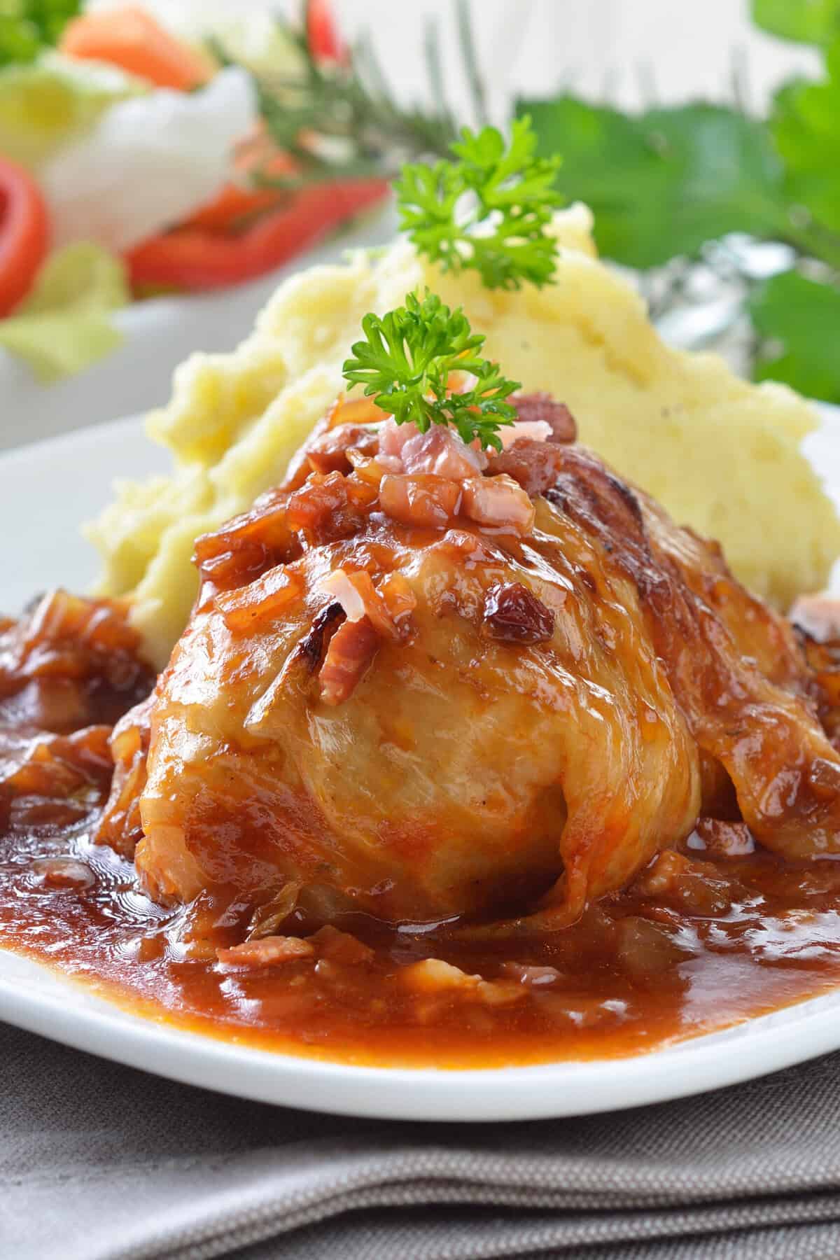 Closeup vertical view of Cabbage Rolls in tomato sauce with apples.
