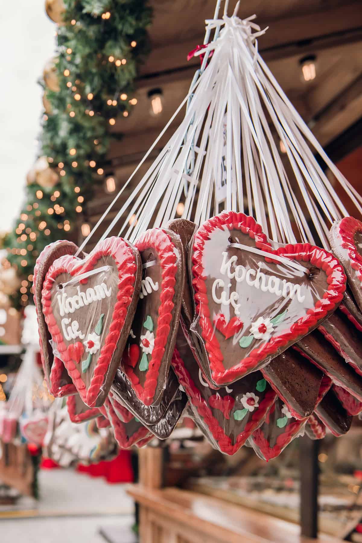 Christmas market gingerbread cookies with German writing and a large Christmas tree in the background.