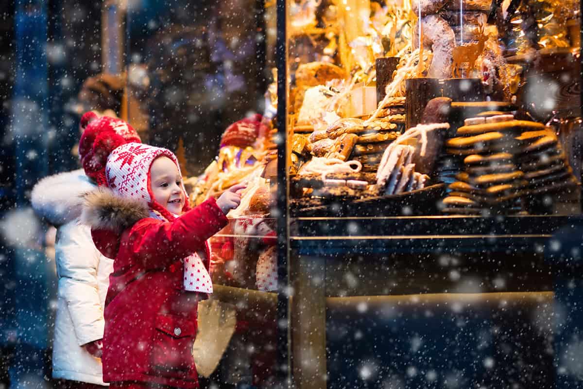 Children pointing at treats and cookies found at a German Christmas Market.