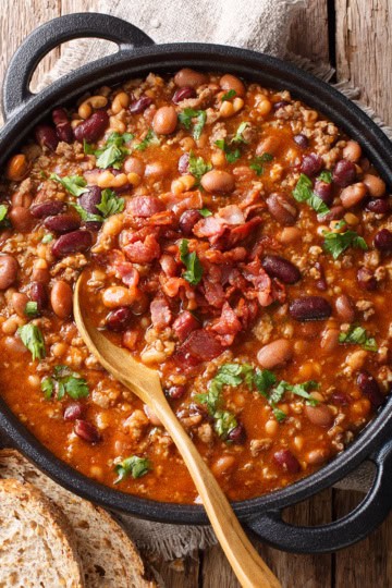 Crockpot Turkey Chili topped with fresh parsley in a large pot with whole grain bread for serving nearby.