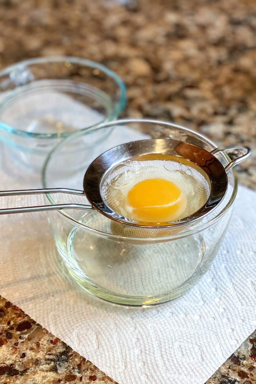 Straining an egg for poaching