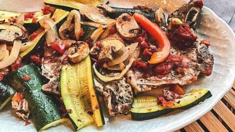 Italian Pork Chops on White Plate with seasonal vegetables,