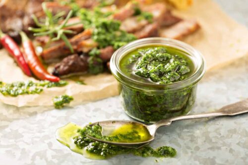 Chimichurri in a small glass bowl with spoon