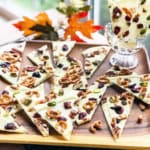 Square image of triangle portions of white chocolate park with pistachios, pretzels, and dried fruit.