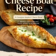 A golden-brown cheese-filled Georgian cheese boat, khachapuri, sits on a wooden board, garnished with herbs; cherry tomatoes and basil are in the background.