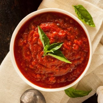 Top view of Marcella Hazan's 3 ingredient tomato sauce with sprigs of fresh basil.