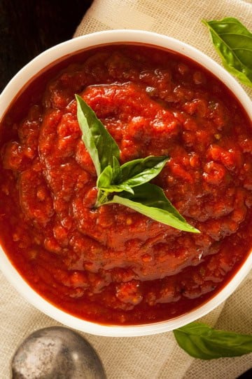 Top view of Marcella Hazan's 3 ingredient tomato sauce with sprigs of fresh basil.