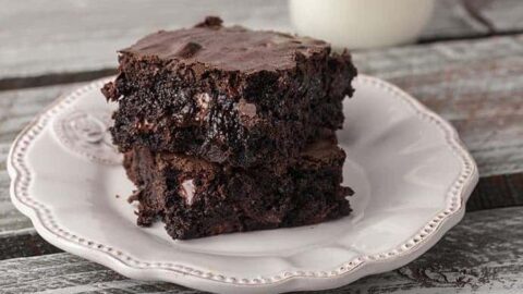 2 stacked brownies on a white plate
