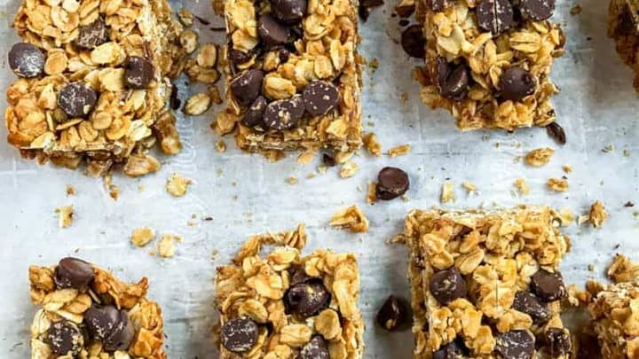 Peanut butter granola bars with chocolate chips arranged in neat rows on parchment paper.