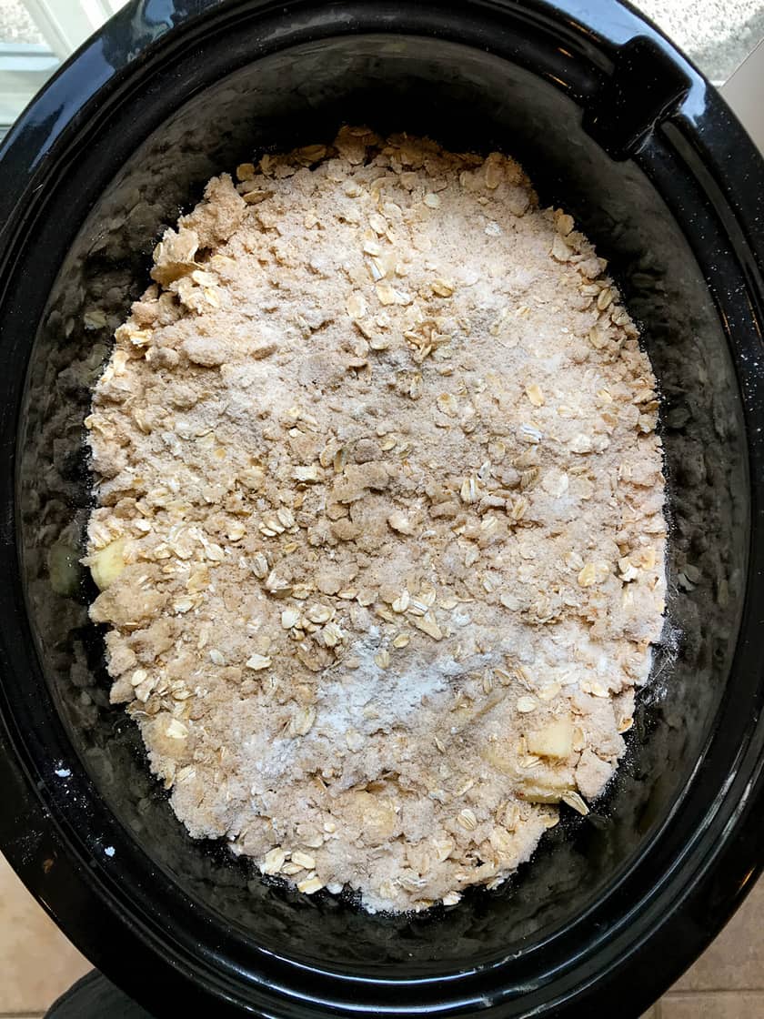 unbaked apple crisp with topping in crockpot