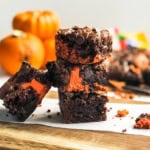 Stack of Peanut Chocolate Swirl Brownies with pumpkins in the background for Halloween.