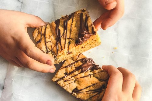 children reaching for chocolate chip cookie bars