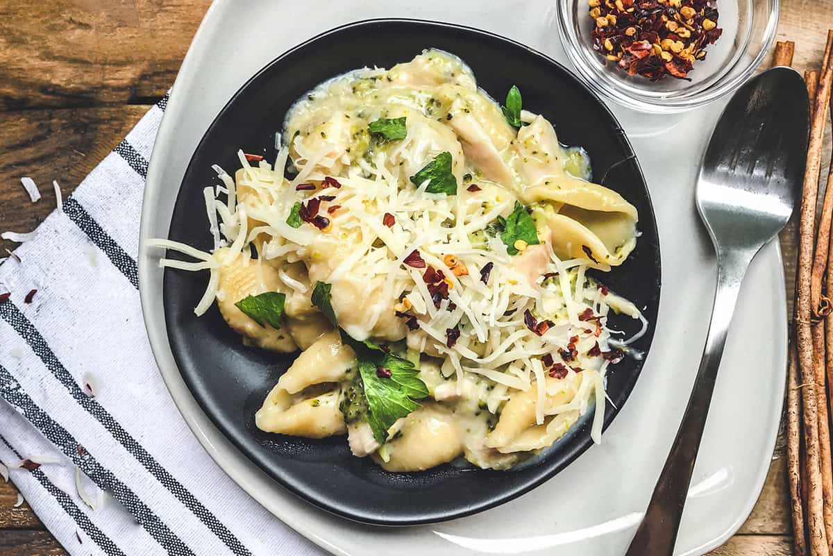 A plate of creamy instant pot mac and cheese, topped with fresh herbs.