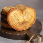 Square image of Palmier on dark wooden serving board with more stacked behind.