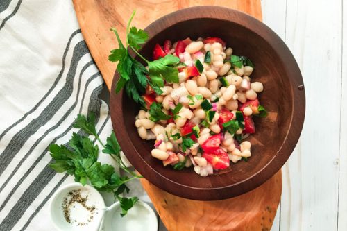closeup of white bean salad in a wooden bowl