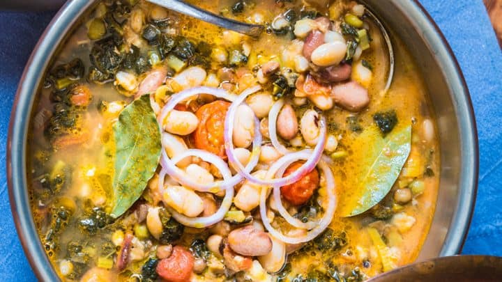 Overhead View of Tuscan Bean Soup in Copper Pot with Onions and Bay Leaves