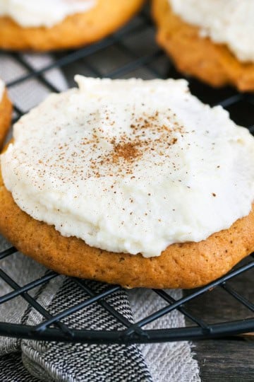Closeup of a frosted pumpkin spice cookie sprinkled with pumpkin pie spice.