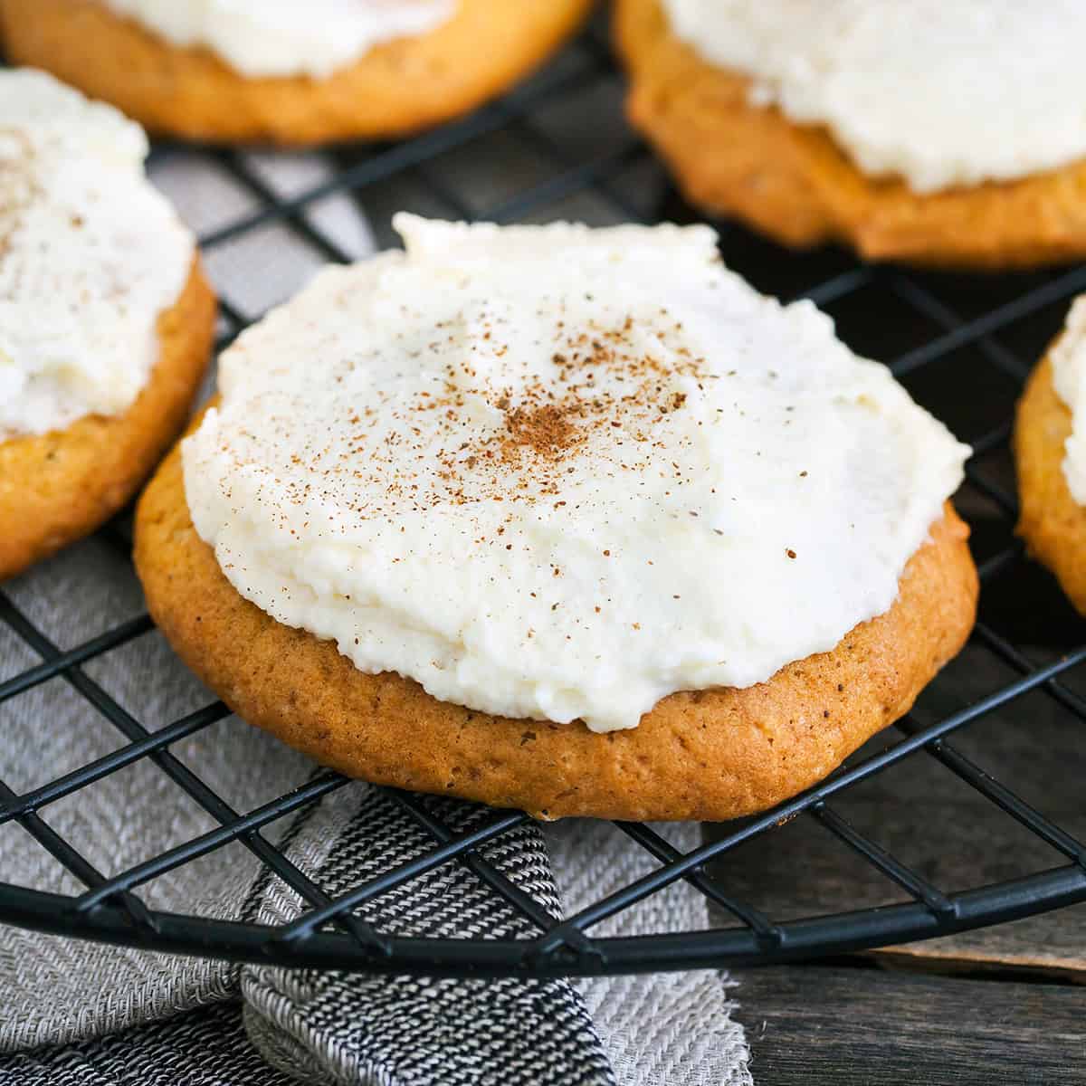 Closeup of a frosted pumpkin spice cookie sprinkled with pumpkin pie spice.