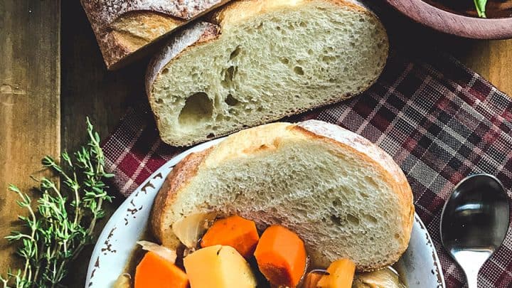 Beef Stew with Sliced Bread on Wooden Board and a bowl of side salad.
