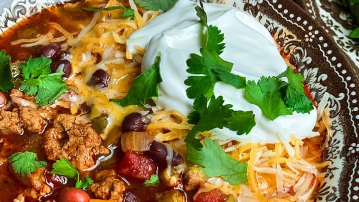 closeup of a bowl of turkey chili in brown transferware bowl