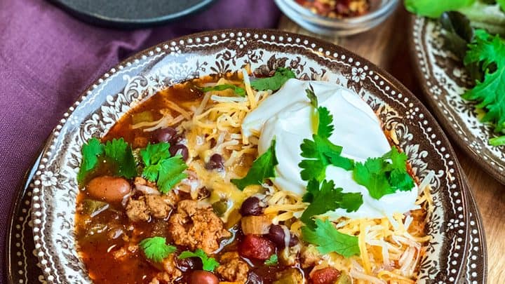 bowl of turkey chili with salad and corn muffins