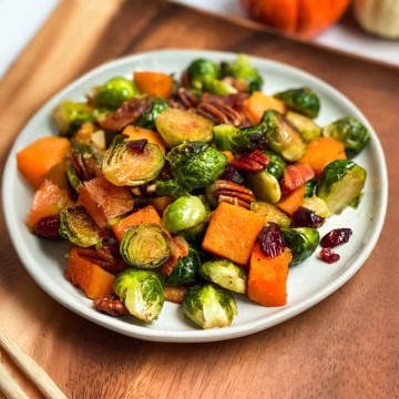 Square image of roasted Brussels Sprouts, butternut squash, and root vegetables on a serving platter.