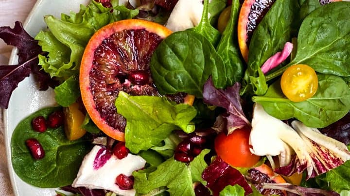 closeup of salad winter greens with blood orange slices