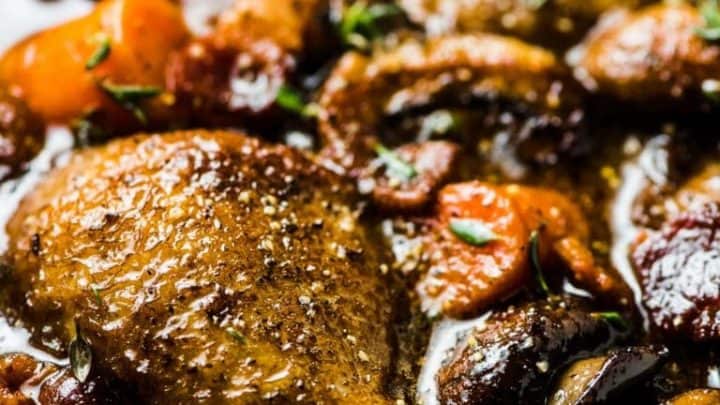 Three floral-patterned plates hold Strawberry Napoleon pastry stacks with cream and strawberries, garnished with mint leaves. The desserts rest on a lace cloth, creating a vintage and elegant presentation.