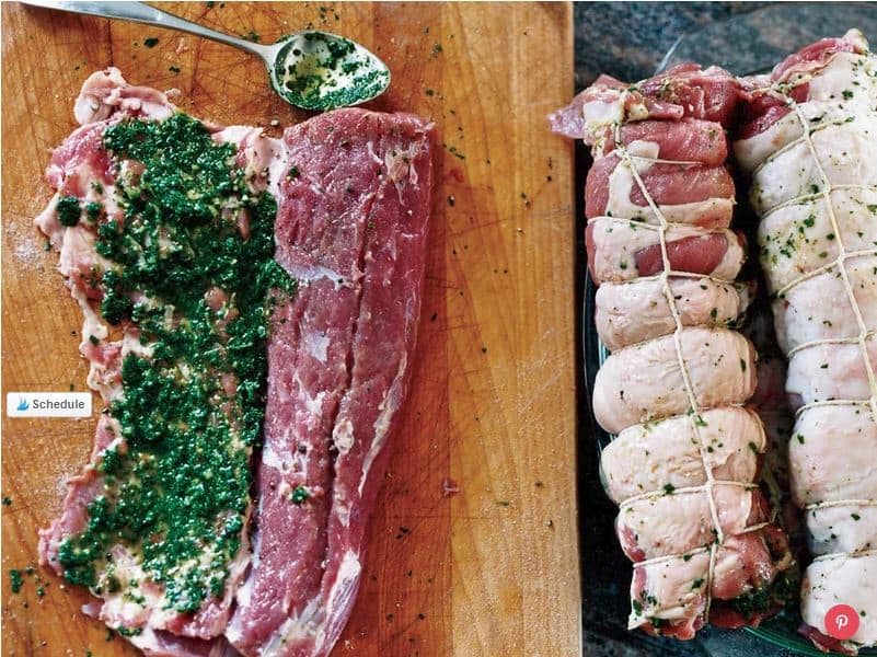 Raw pork tenderloin is spread with a green herb mixture on a wooden surface; next to it are tied, stuffed pork fillets ready for cooking, inspired by classic Irish pub recipes.