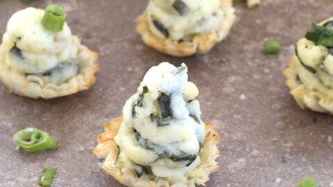 A rustic ceramic bowl filled with creamy potato soup, garnished with a drizzle of olive oil, freshly ground black pepper, and a sprig of thyme. The bowl rests on a wooden table, adding to the warm and comforting presentation of the dish.