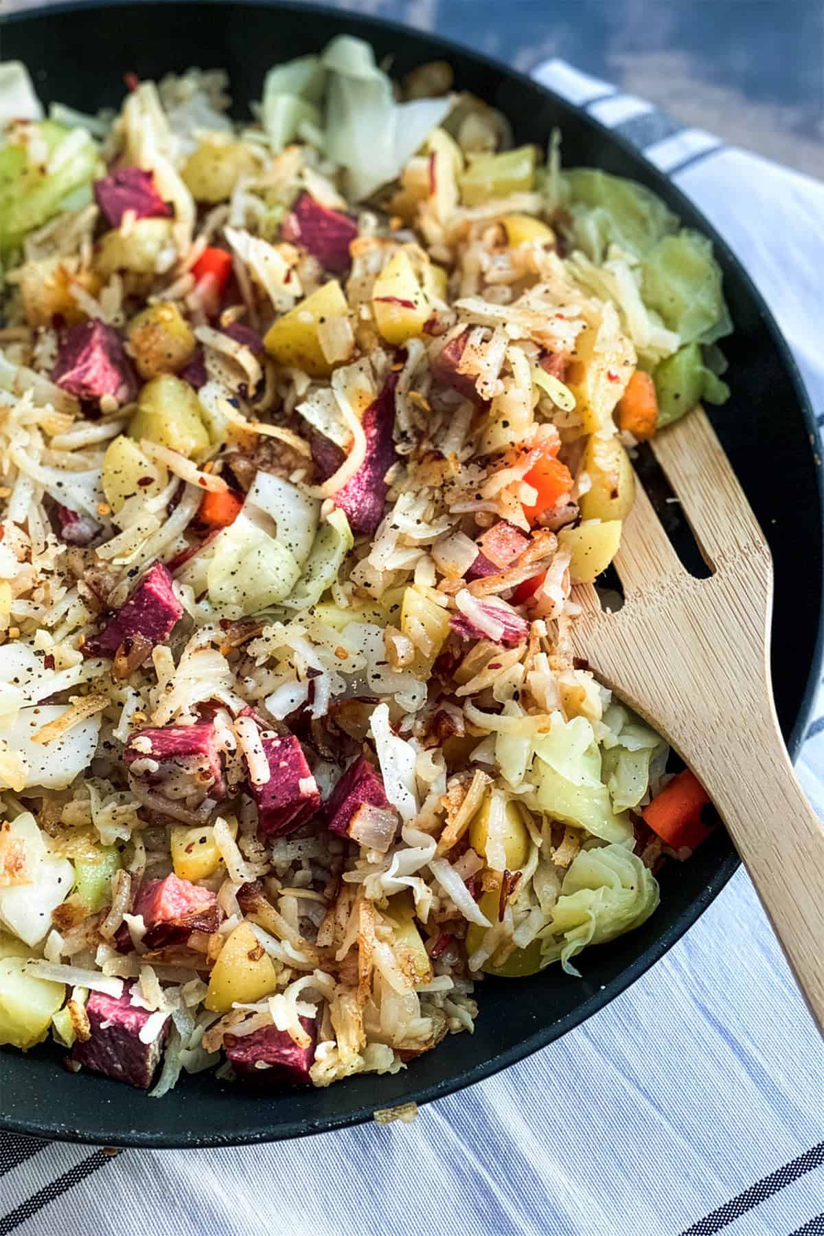 A skillet of saut&eacute;ed vegetables, cabbage, potatoes, and carrots creates a hearty Corned Beef Hash.