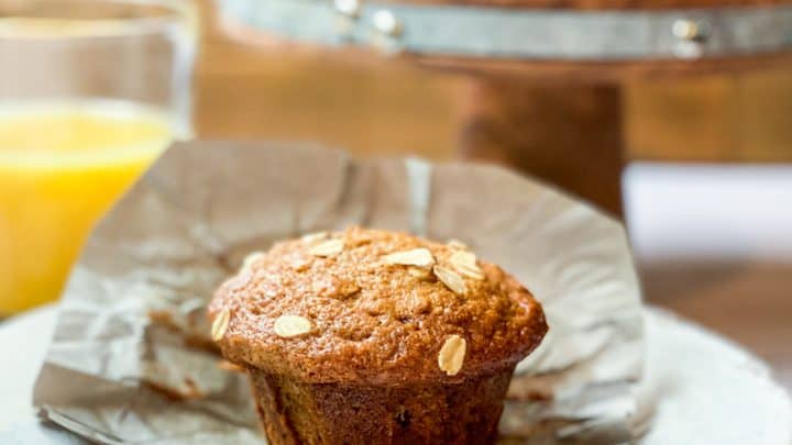 Unwrapped Morning Glory Muffin on a Plate with Orange Juice
