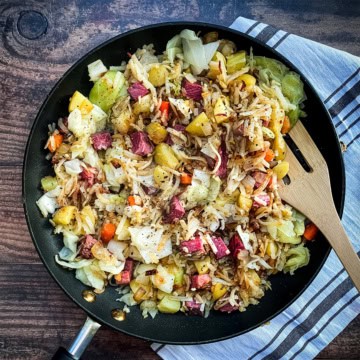 A skillet of classic Corned Beef Hash with diced corned beef, potatoes, cabbage, and carrots.