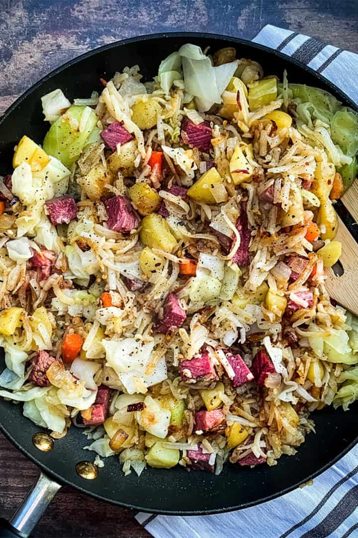 A skillet of classic Corned Beef Hash with diced corned beef, potatoes, cabbage, and carrots.