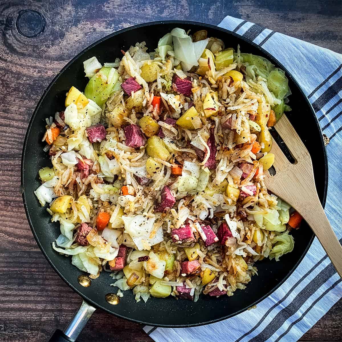 A skillet of classic Corned Beef Hash with diced corned beef, potatoes, cabbage, and carrots.