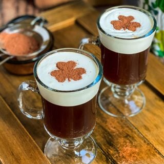 Two mugs of Irish Coffee with shamrock latte art