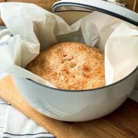 Vertical View of No Knead Whole Wheat Bread in a White Dutch Oven
