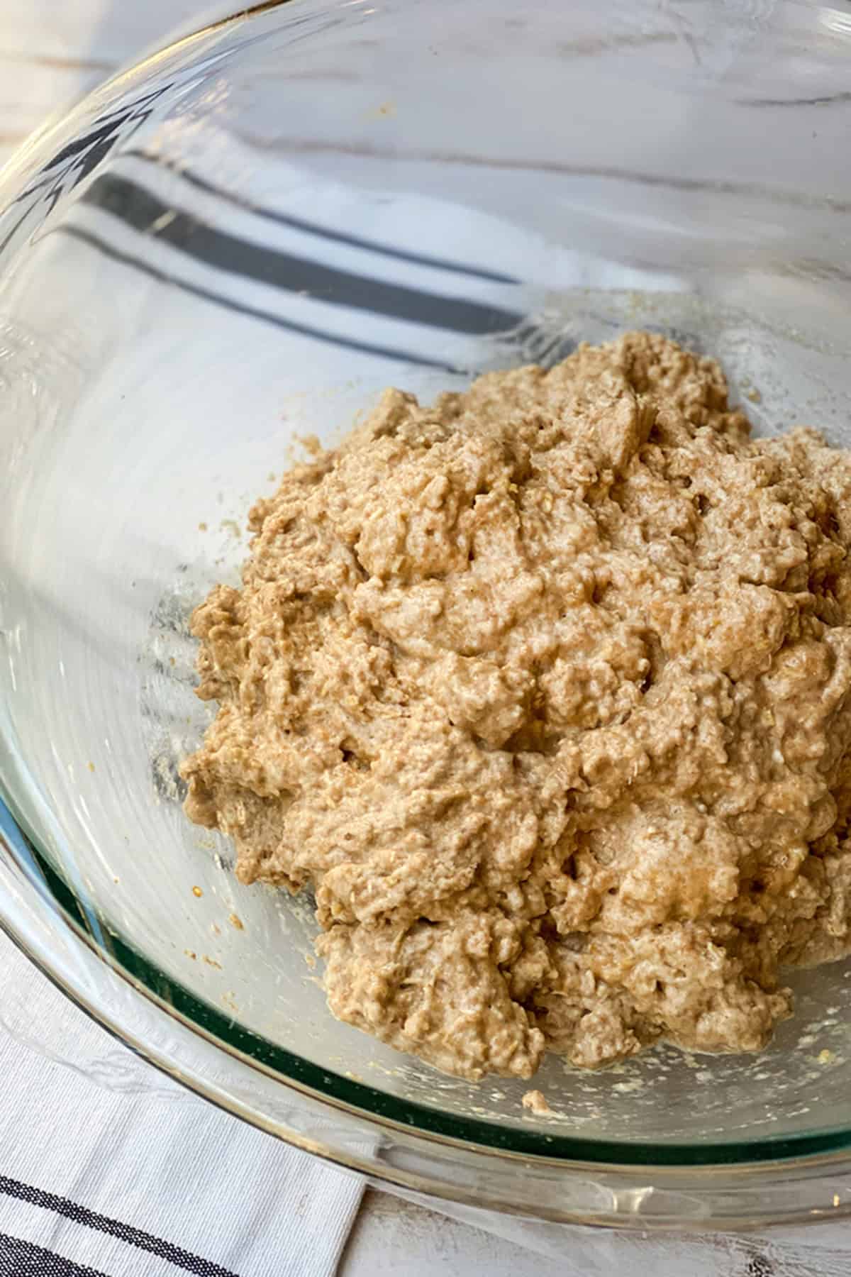 Mixing the no knead bread ingredients in a glass bowl into a shaggy dough.