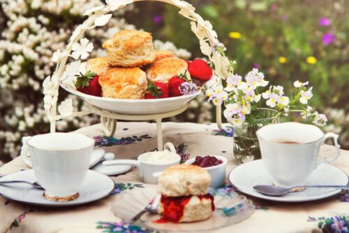 Side view of English Scones at an outside tea table with strawberry jam