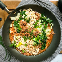 Top view of Ginger Pork Noodles with Bok Choy in a black skillet